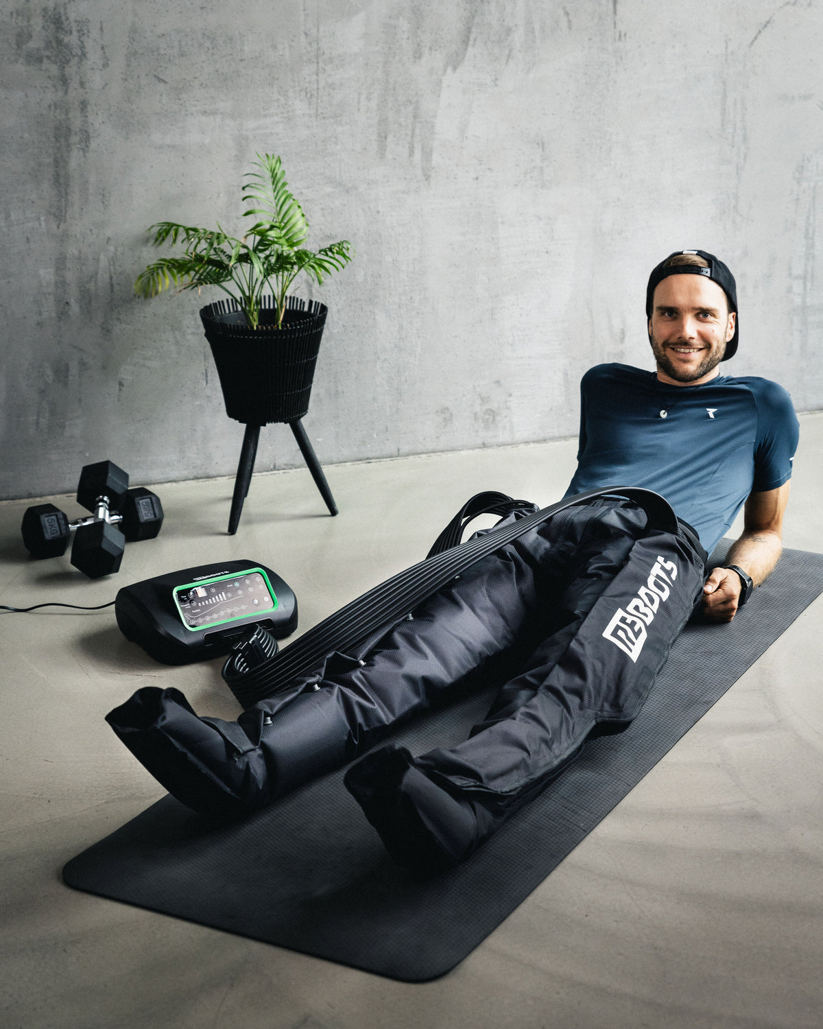 Reboots: Mann benutzt Reboots Kompression liegend auf Sportmatte