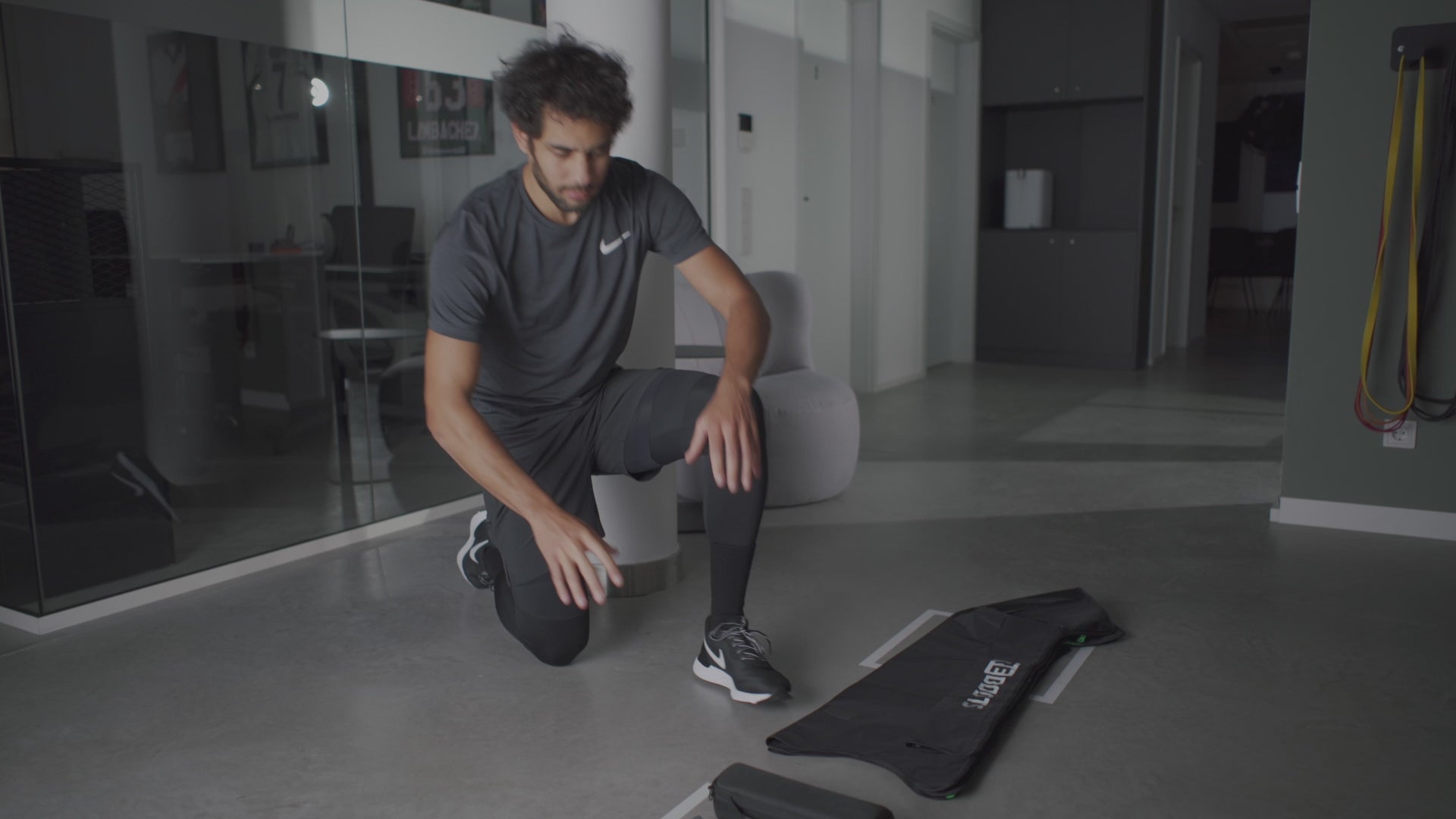 Load video: Reboots: Sportler im Gym kniet neben Kompressionshose