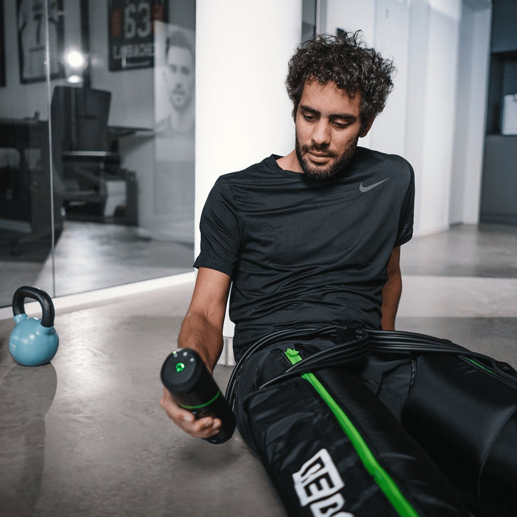 Reboots: Hombre con barba y camiseta negra se recupera con la terapia de compresión deportiva GO LITE.