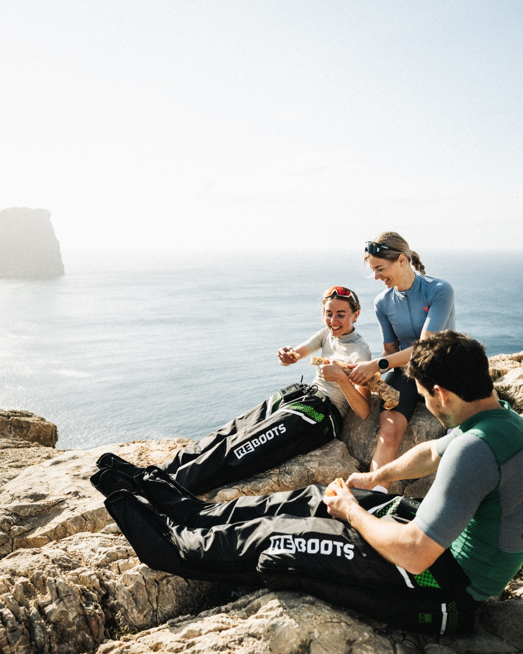 Gruppe von Sportlern auf einer Klippe, die die Reboots-Drucktherapie anwenden.